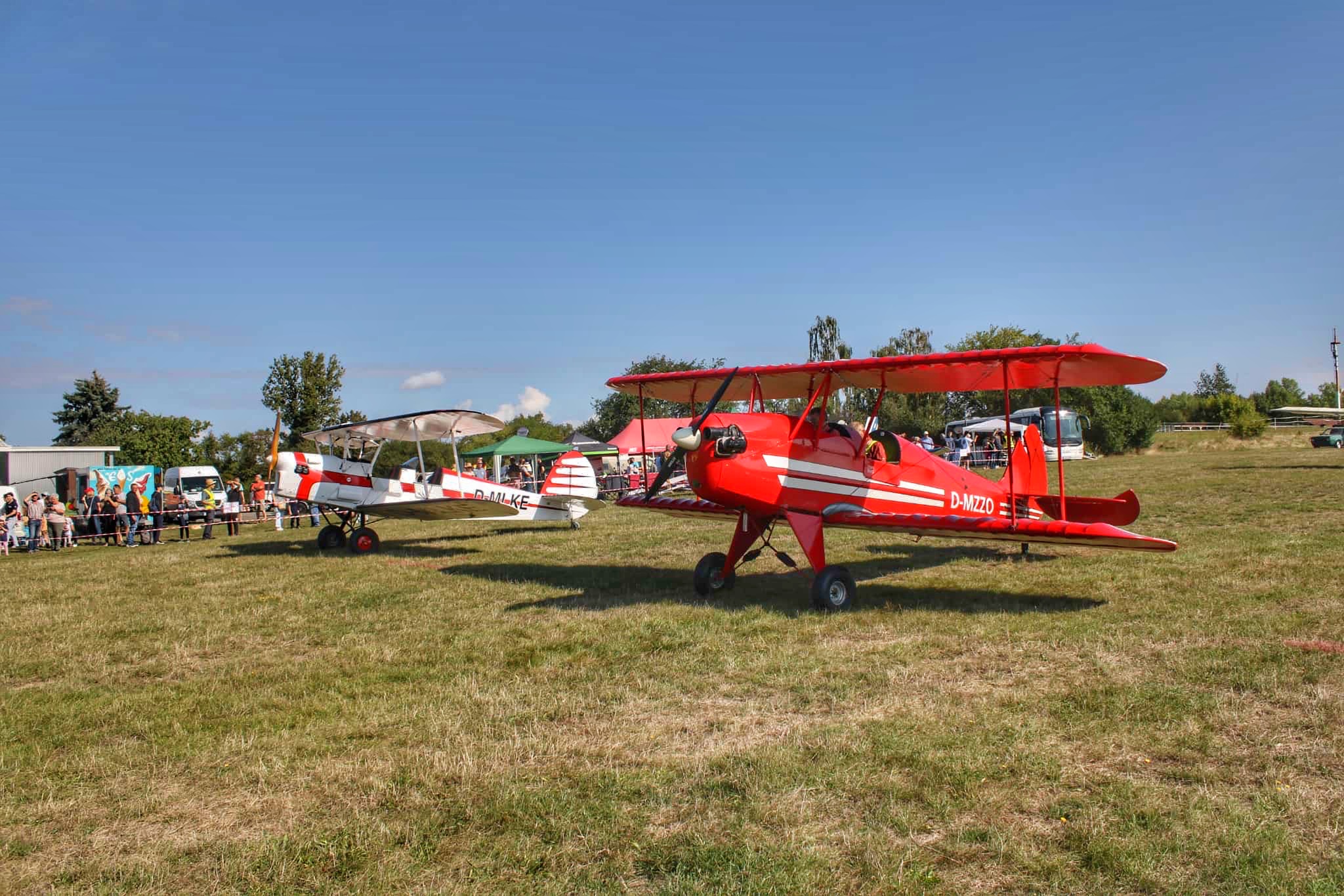 Rückblick: Flugplatzfest Taucha 2025 – Ein unvergesslicher Tag für rund 3.000 Besucher Zuschauer bestaunen zwei historische Doppeldecker-Flugzeuge auf einer grünen Wiese während einer Flugschau