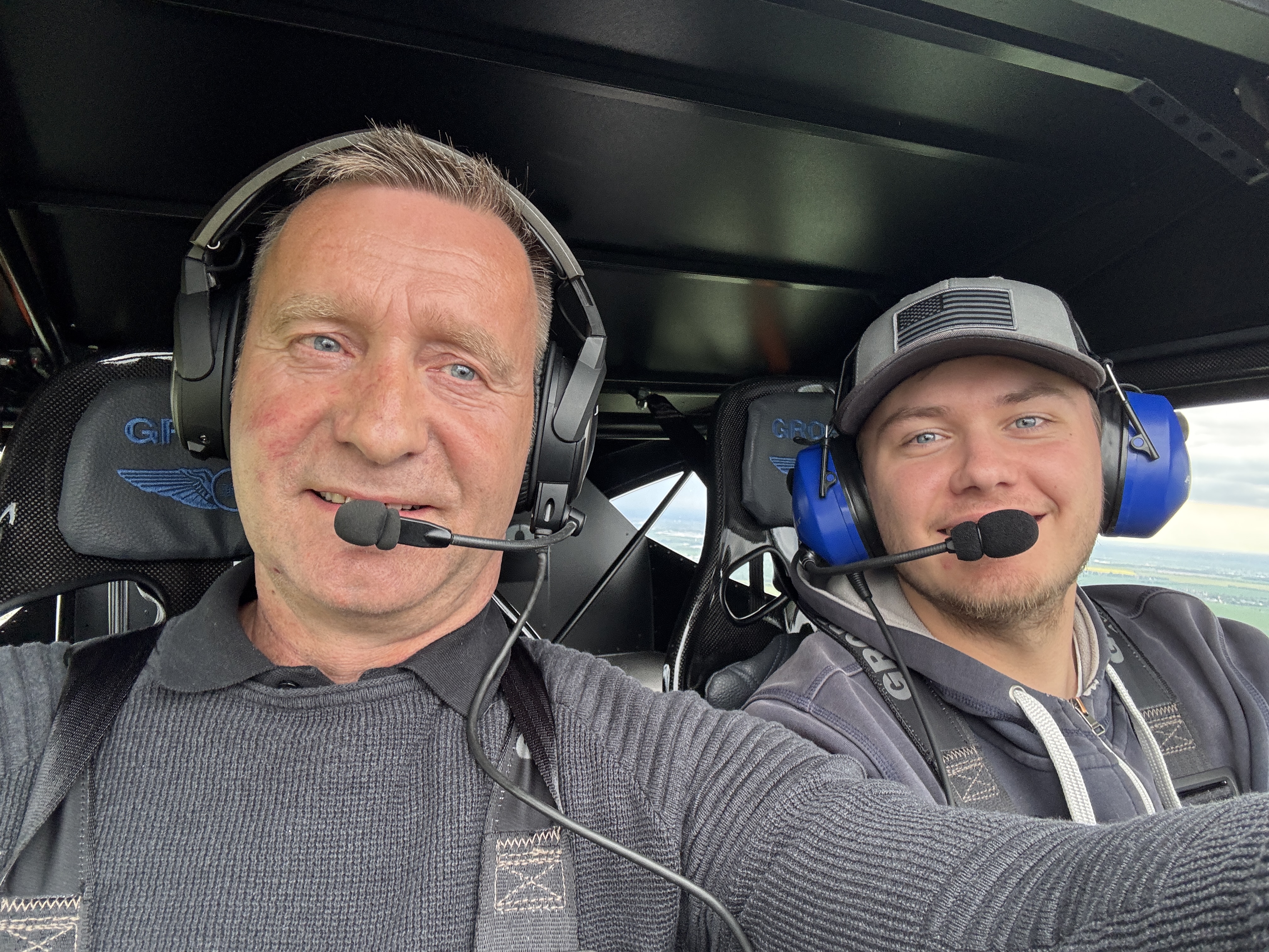 Zwei Männer im Cockpit eines Flugzeugs, beide mit Headsets, während eines Flugs