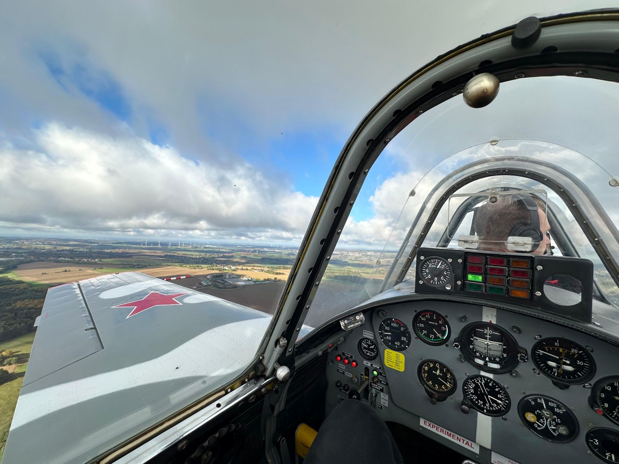 Blick aus dem Flugzeugcockpit auf Landschaft und Instrumente